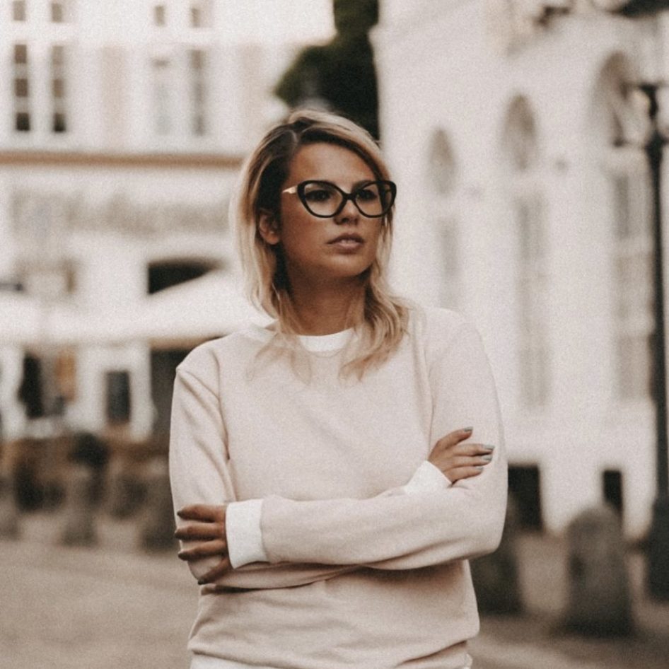 Influencerin Marina_lovesnyc steht vor weißen Häusern und trägt eine Brille von Sylvie Optics.